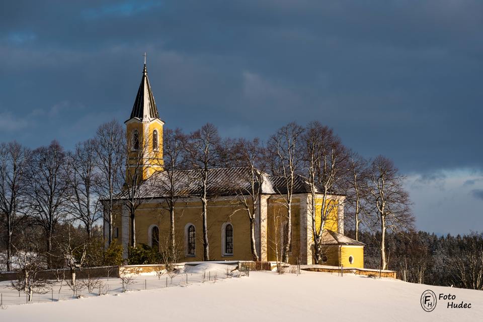 Zimní kostel sv. Mikuláše ve večerním slunci.
